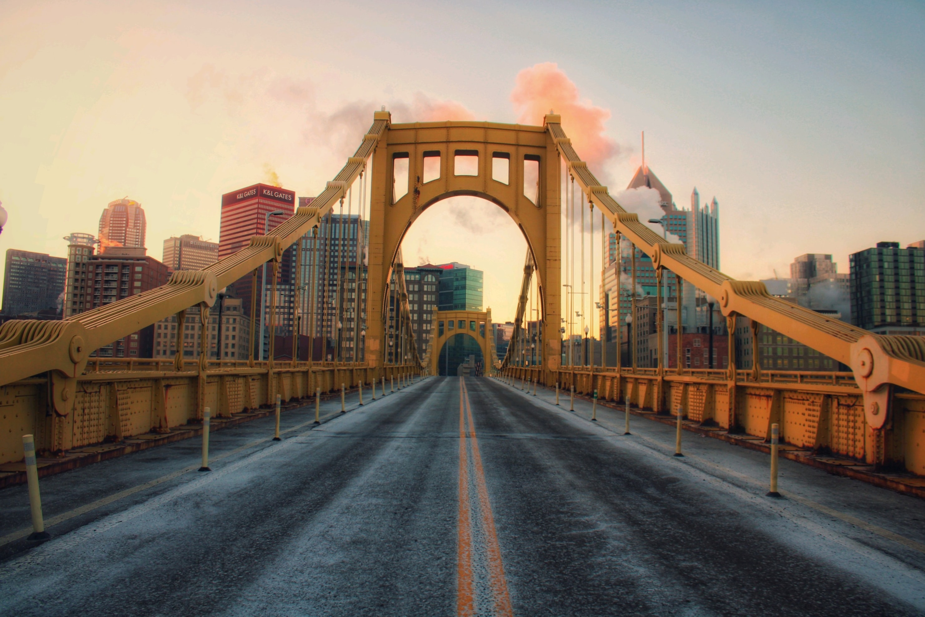 A Pittsburgh bridge road at sunrise, looking toward the downtown skyline
